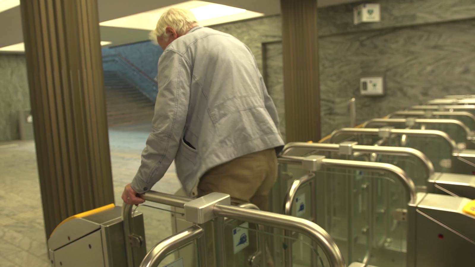 Bejaarden klimt over NS poortje